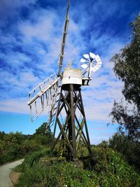 Traditional windmill on field against sky