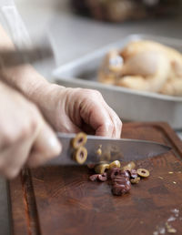 Hands chopping olives