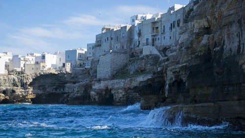 Scenic view of buildings on cliff by sea