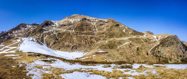 Scenic view of snowcapped mountains against clear blue sky