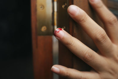 Close-up of injured finger of woman by door