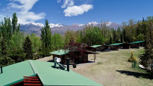 Scenic view of trees and houses against sky