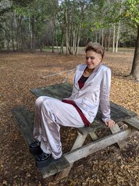 Young woman sitting on bench in field