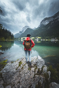 Rear view of man standing in lake against sky