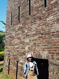 Man standing against brick wall