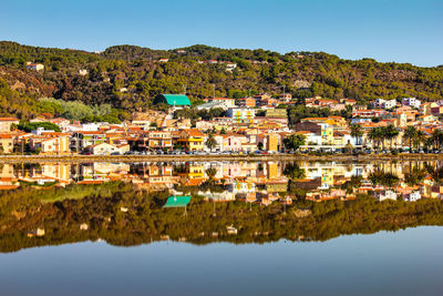 Townscape by lake against sky in town