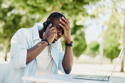 Side view of young man using mobile phone