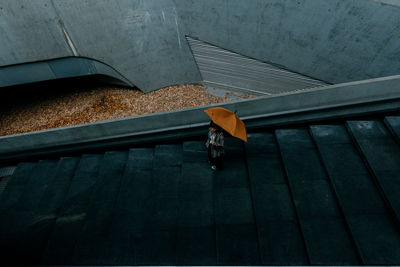 Woman with umbrella standing on steps