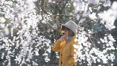Rear view of woman standing against trees