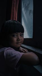 Side view of young woman sitting on sofa at home