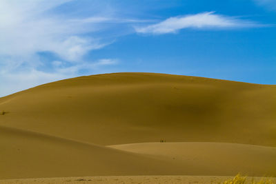 Close-up of sand dunes against blue sky