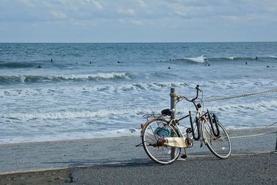 Bicycle on beach against sky