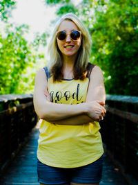 Portrait of young woman wearing sunglasses standing outdoors