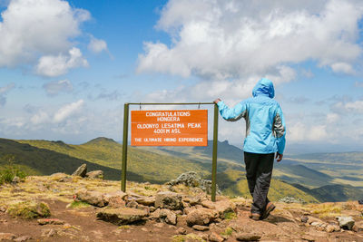 A hiker standing next to a sign post at ol doinyo lesatima in the aberdares, kenya