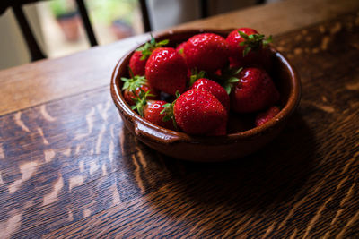 Bowl of strawberries on a wooden table