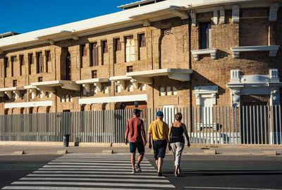 Rear view of people walking on building in city