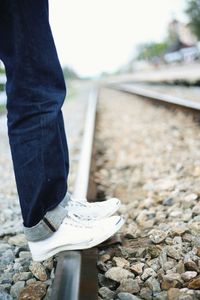 Low section of man standing on railroad track