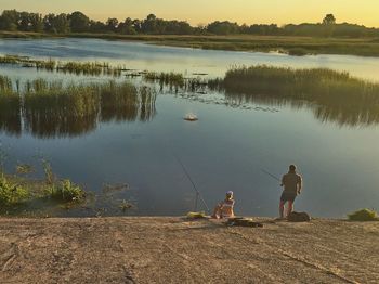 Reflection of man fishing in lake