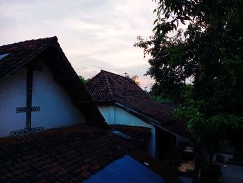 House by building against sky at dusk