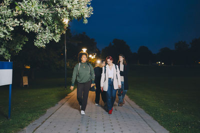 People walking on footpath at night