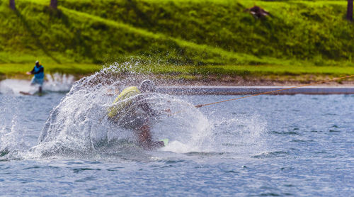 Man splashing water while kiteboarding on sea