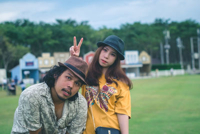 Portrait of young woman standing against blurred background
