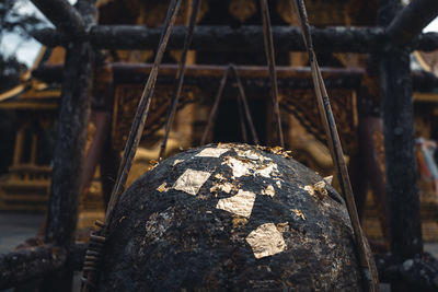 Close-up of old rusty metal on rock against building