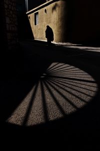 Low section of person walking on street against building