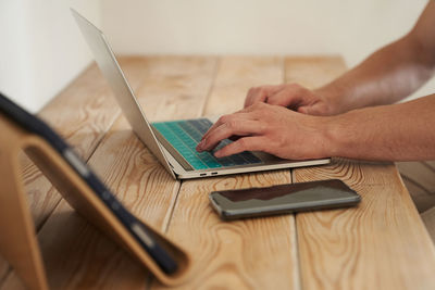 Cropped hands using laptop on table