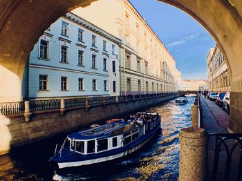 Canal amidst buildings in city against sky