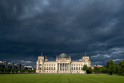 Buildings in city against cloudy sky