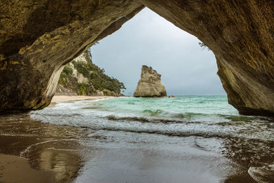Rock formation on beach against sky