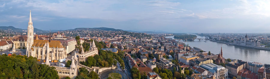 High angle view of city by river against sky