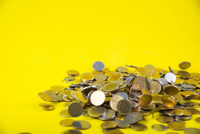 Close-up of coins on yellow background