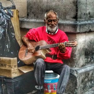 Portrait of man sitting in guitar