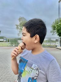 Side view of boy eating ice cream cone