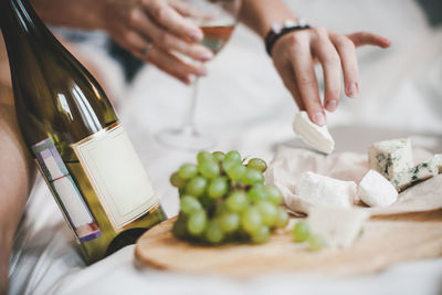 Grapes and bottle of white wine with cheese plate for the lunch in bedroom