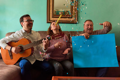 Portrait of happy man playing on sofa