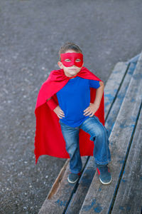 Portrait of boy in superman costume standing on steps