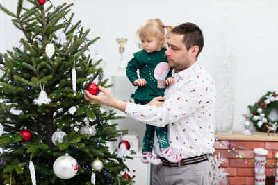 Side view of woman holding christmas tree