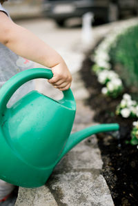 Little girl watering plants at home clos.