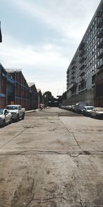 Cars on city street against sky