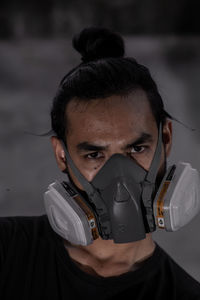 Portrait of man wearing protective mask holding equipment at workshop