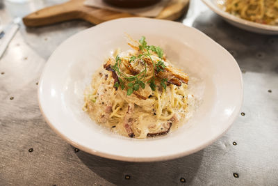 High angle view of carbonara pasta in plate on table