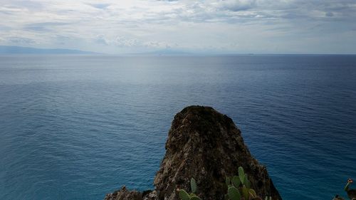 Scenic view of rock formation in sea against sky