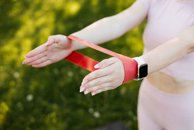 Sports girl doing exercise with rubber bands for fitness in the park