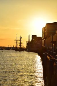 Canal amidst buildings against sky during sunset