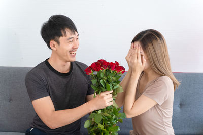 Young couple standing against blue sky