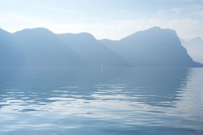 Scenic view of sea and mountains against sky