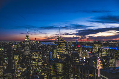 Illuminated cityscape against blue sky